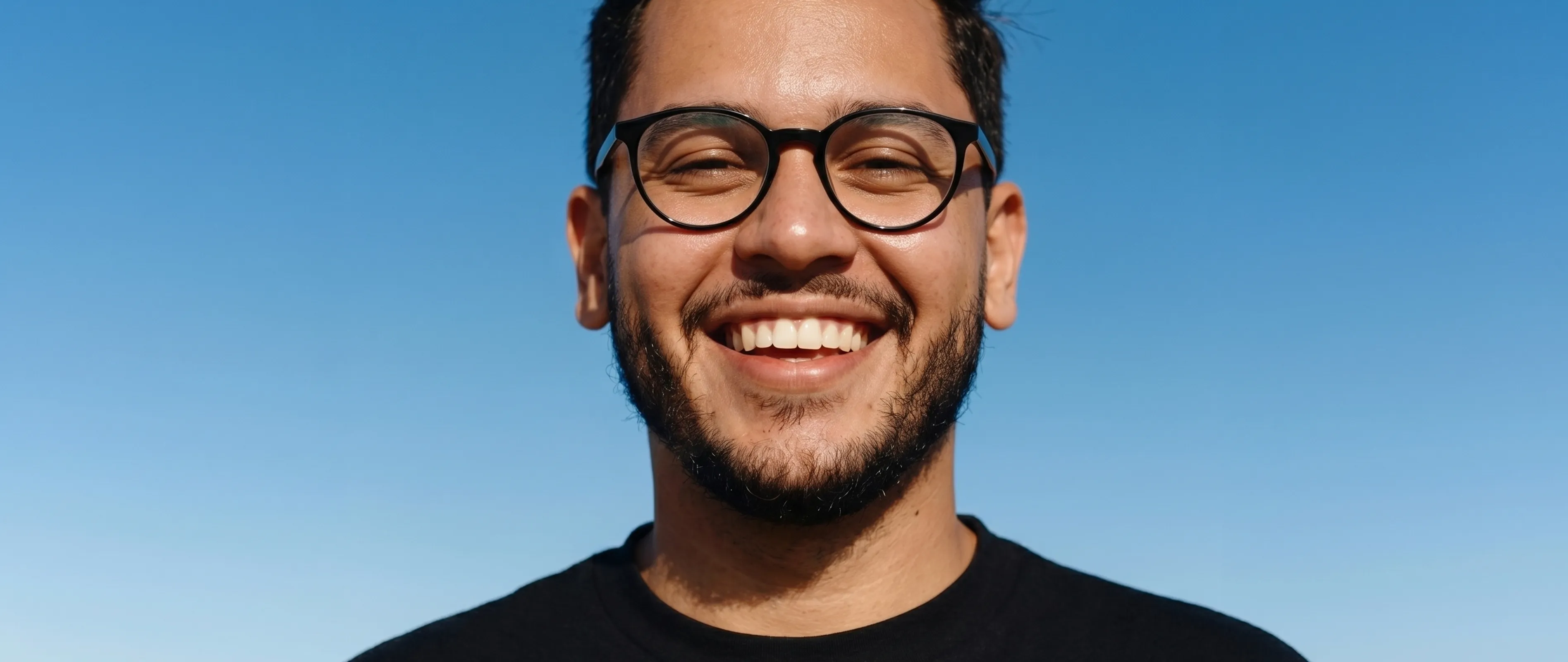Lächelnder Mann vor blauem Himmel, der sich mit Everyman um seine Gesundheit kümmert